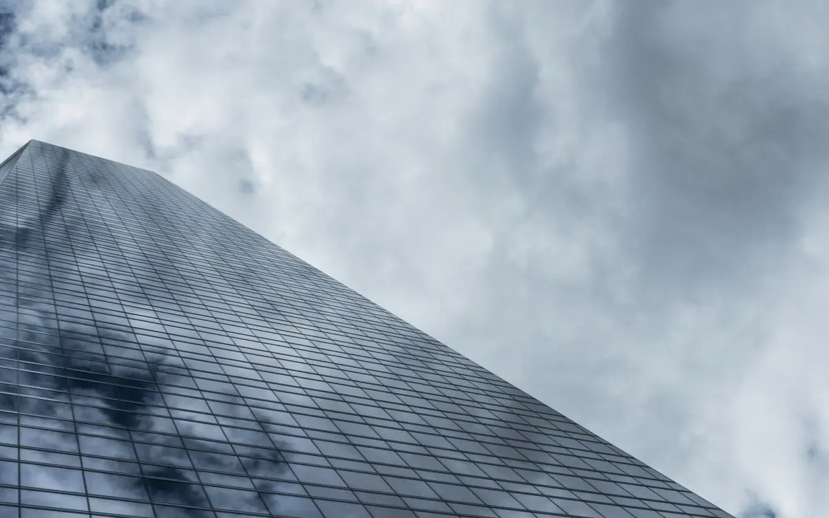 Low angle view of a towering modern skyscraper with glass wi